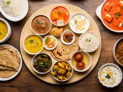Indian thali with rice, dal, chapati, sabzi, and sides on a wooden table